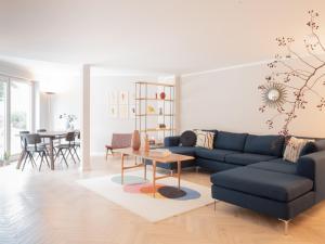 ein Wohnzimmer mit einer blauen Couch und einem Tisch in der Unterkunft Das Sellin - Auszeit mit eigenem Seezugang und Sonnengarten in Heringsdorf