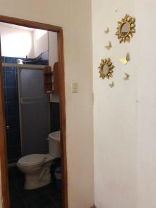 uma casa de banho com WC e borboletas na parede em UFO House em Montañita