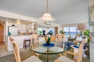a kitchen and living room with a glass table and chairs at Ilikai #1743 Panoramic views on Waikiki Beach in Honolulu