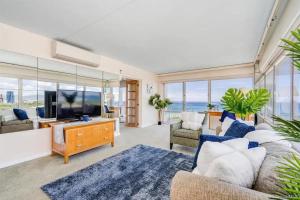 a living room with a couch and a tv at Ilikai #1743 Panoramic views on Waikiki Beach in Honolulu