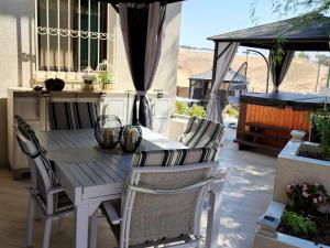 a wooden table and chairs on a patio at Dead Sea-Sunny Holidays Village & SPA in Arad