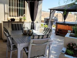 a wooden table and chairs on a patio at Dead Sea - Village & SPA in Arad