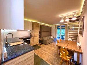 una cucina e un soggiorno con tavolo in legno di La Baita Limone Riserva Bianca Ski-in Ski-out Seggiovia Morel 1 a Limone Piemonte