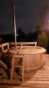 a wooden hot tub sitting on a deck at night at Cabañas El Roble in Dalcahue