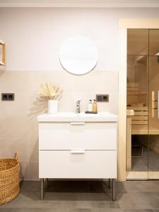 ein Badezimmer mit einem weißen Waschbecken und einem Spiegel in der Unterkunft Das Sellin - Auszeit mit eigenem Seezugang und Sonnengarten in Heringsdorf + 22 Fotos