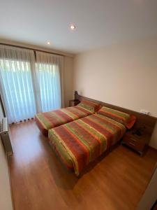 a bedroom with a bed with a striped comforter at Els Verns in Ribes de Freser