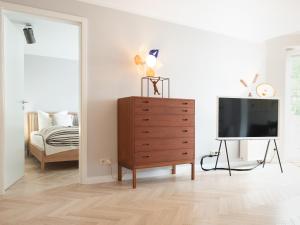 ein Wohnzimmer mit einem TV und einer Kommode in der Unterkunft Das Sellin - Auszeit mit eigenem Seezugang und Sonnengarten in Heringsdorf