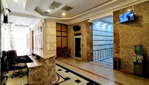 a lobby with a room with a television on the wall at Leyla Apartments 2 in Baku
