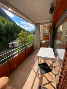 a balcony with a table and a view of the mountains at Els Verns in Ribes de Freser