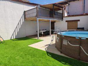 a backyard with a swimming pool and green grass at CASA RURAL VEGASAN in Santa Colomba de la Vega