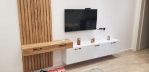 a living room with a tv on a wall at 2A New Bazaar Apartment in Tirana