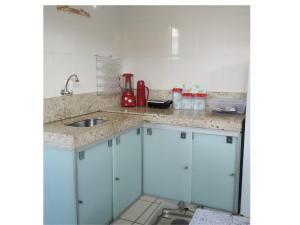 a kitchen with blue cabinets and a sink at RESIDÊNCIA MORADA DO SOL in Nova Viçosa