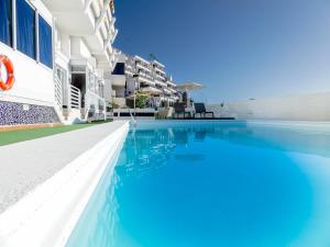 una piscina di fronte a un edificio di Apartamentos Guadalupe Gran Canaria Puerto Rico a Mogán