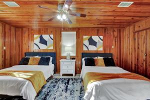 a bedroom with two beds and a ceiling fan at Lake Haven Cottage On Lake Hamilton in Hot Springs