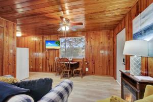 a living room with a ceiling fan and a table at Lake Haven Cottage On Lake Hamilton in Hot Springs