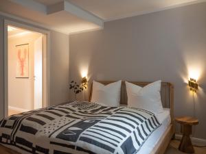 ein Schlafzimmer mit einem großen Bett mit weißen Kissen in der Unterkunft Das Sellin - Auszeit mit eigenem Seezugang und Sonnengarten in Heringsdorf