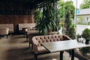 una fila de sillas y mesas en una habitación con plantas en Premiere Hotel, en Khust