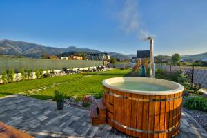 a large wooden tub with a fountain in a yard at Chalet West - Zuberec in Zuberec +54 photos