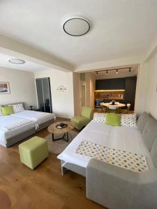 Apartment N & N في ستروغا: غرفة معيشة بها سريرين وأريكة