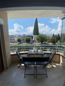 eine Terrasse mit einem Tisch und Stühlen sowie einem großen Fenster in der Unterkunft Apartment N & N in Struga