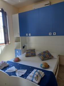 - une chambre avec un lit doté de placards bleus et d'oreillers dans l'établissement Villa Serena, à Granelli