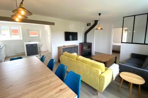 een woonkamer met een tafel en een gele bank bij Saint-Pol family house garden fully equipped 12 people in Saint-Pol-de-Léon