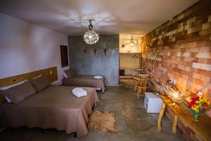 a room with two beds and a brick wall at Pousada Matuto Sonhador in Cabaceiras