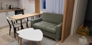 a living room with a green couch and a table at 2A New Bazaar Apartment in Tirana