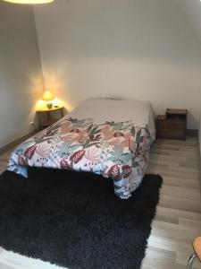 1 dormitorio con 1 cama con edredón de flores en La Résidence de Marie, en Brommat
