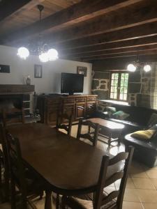 a living room with tables and a couch and a television at La Résidence de Marie in Brommat