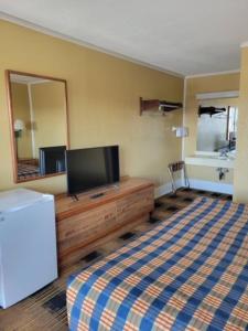 ein Wohnzimmer mit einem TV auf einer Holzkommode in der Unterkunft Smokies Inn - New Linens & Ultrafast WIFI - Friendliest Hospitality Guaranteed! in Kodak