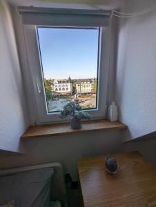 - une fenêtre dans une chambre avec une table en face dans l'établissement Schönes 2 Zimmer Appartment in der Altstadt von Koblenz, à Coblence