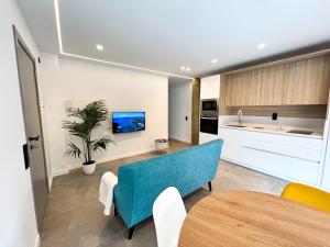 cocina y sala de estar con sofá azul y mesa en La Cala de Alcalá Luxury en Alcalá