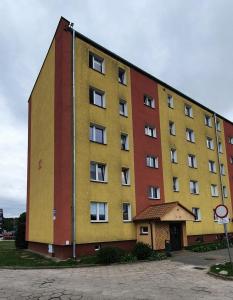 un grand bâtiment avec des tons jaune et rouge dans l'établissement Lęborska Kajuta, à Lębork