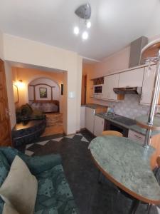a kitchen and living room with a table and a couch at Atgiris in Palanga