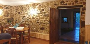 comedor con mesa y pared de piedra en Casa Pregueira, 
