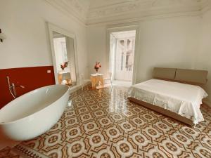 een grote badkamer met een bad en een bed bij Casa di Rita in Catania