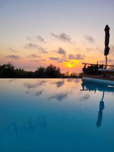 einen Pool mit Sonnenuntergang im Hintergrund in der Unterkunft Villa euphoria in Agios Nikitas