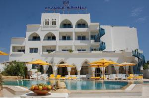 a hotel with a swimming pool in front of a building at Hotel Byzance in Nabeul