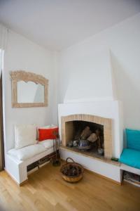 ein Wohnzimmer mit einem Sofa und einem Kamin in der Unterkunft Άνετη διαμονή 100 μέτρα από τη θάλασσα - Βάρκιζα in Vari