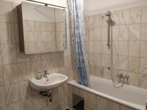 y baño con lavabo, espejo y bañera. en CozyNite Premium Apartment Ottakring, en Viena