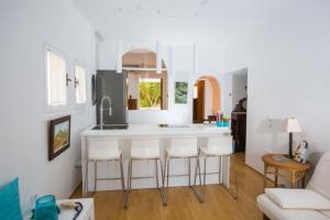 eine Küche mit einer weißen Insel im Wohnzimmer in der Unterkunft Άνετη διαμονή 100 μέτρα από τη θάλασσα - Βάρκιζα in Vari