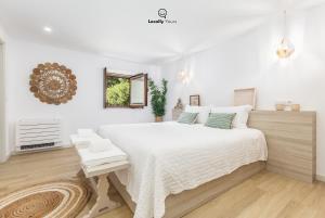 a white bedroom with a large bed and a mirror at Casa do Monte Locally Yours in Caminha