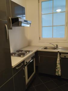 cocina con fregadero, fogones y ventana en CozyNite Premium Apartment Ottakring, en Viena