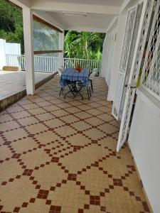 un patio con una mesa en un suelo con suelo de baldosa en Maison chaleureuse avec terrasse et parking privé en Le Lamentin