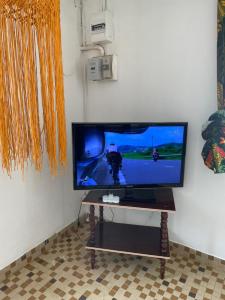 TV de pantalla plana sentada en una mesa en una habitación en Maison chaleureuse avec terrasse et parking privé en Le Lamentin