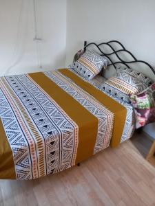 - un lit avec une couverture et des oreillers dans l'établissement Maison chaleureuse avec terrasse et parking privé, au Lamentin