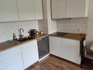 a kitchen with white cabinets and a sink at Mieszkanie przy Błoniach baza wypadowa na Rower in Rumia +10 photos