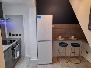 una cucina con frigorifero bianco e 2 sgabelli di 93 Newtown Road a Great Malvern