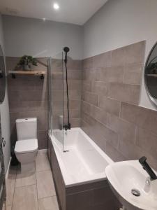 ein Badezimmer mit einer Badewanne, einem WC und einem Waschbecken in der Unterkunft 93 Newtown Road in Great Malvern